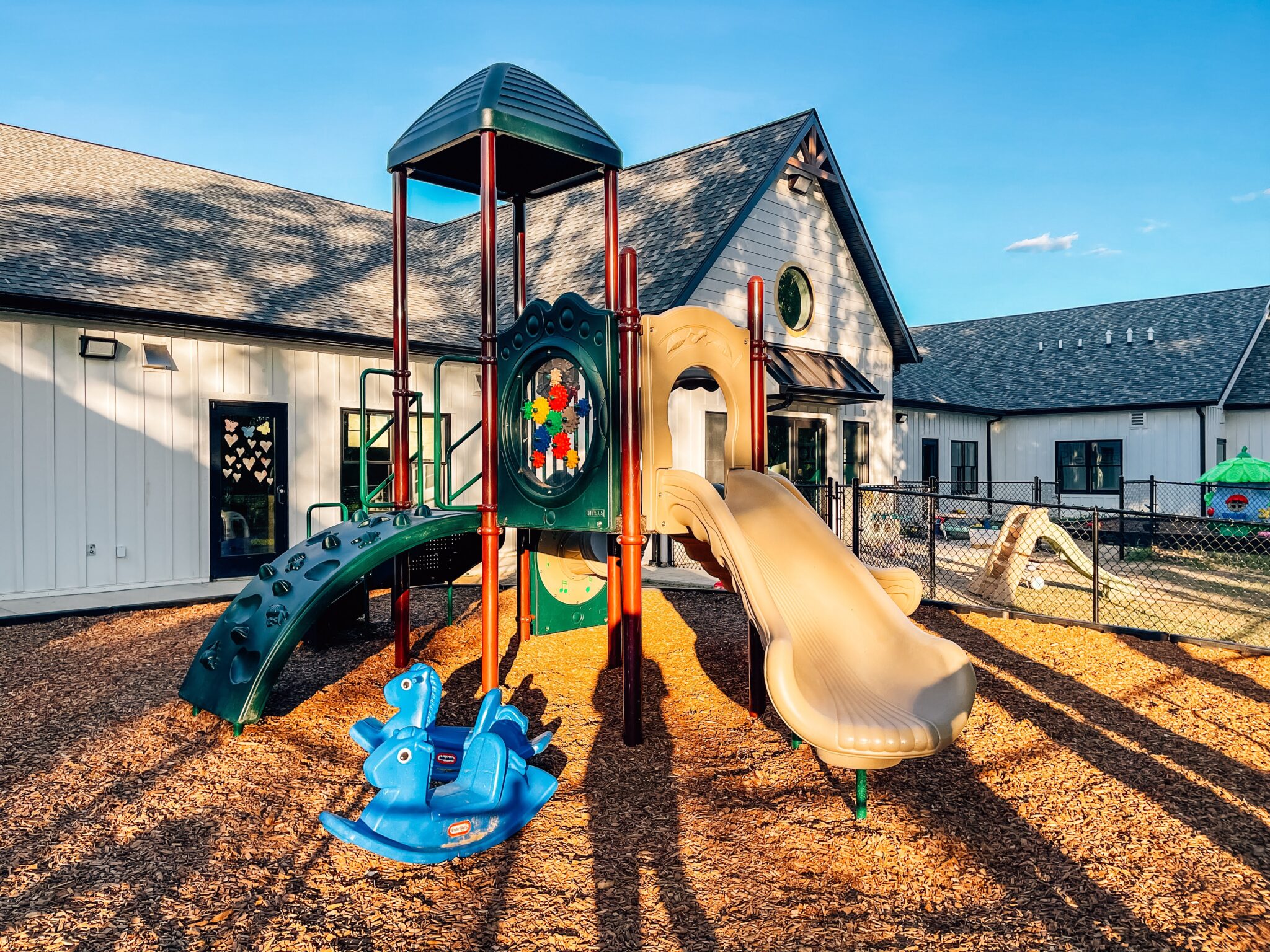 Close-up view of playground equipment including slides, tunnels, and sensory panels