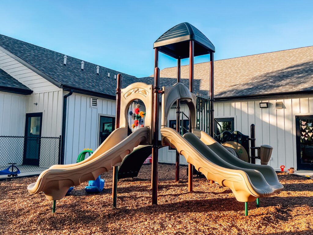Lincoln Play Structure for Ages 2-5 with a double slide, sensory panel, and drums