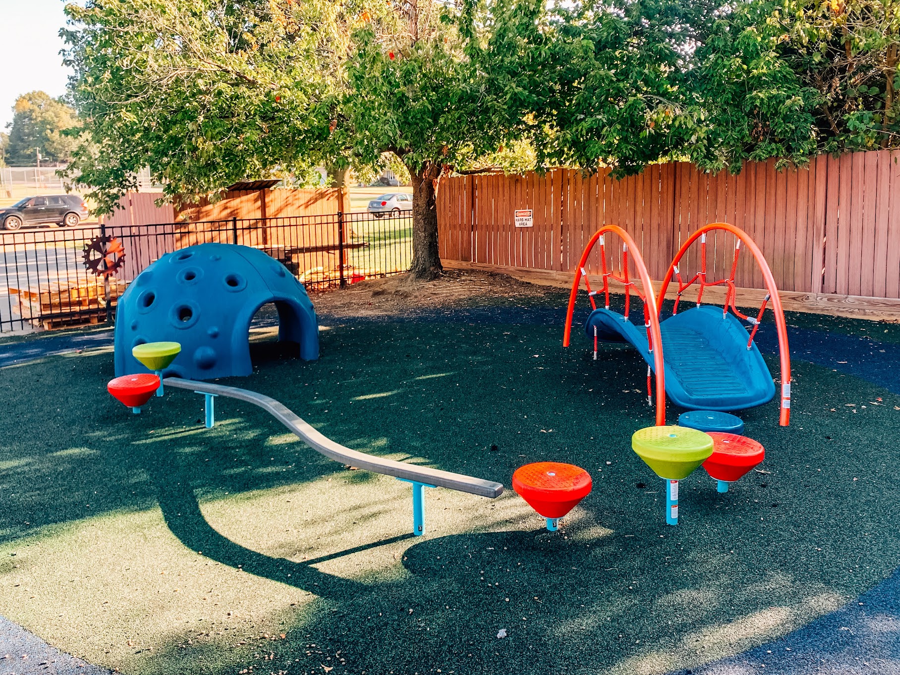 Full view of daycare playground in Huntingburg, Indiana featuring commercial playhouses, shade structure, steppers, and climbing dome