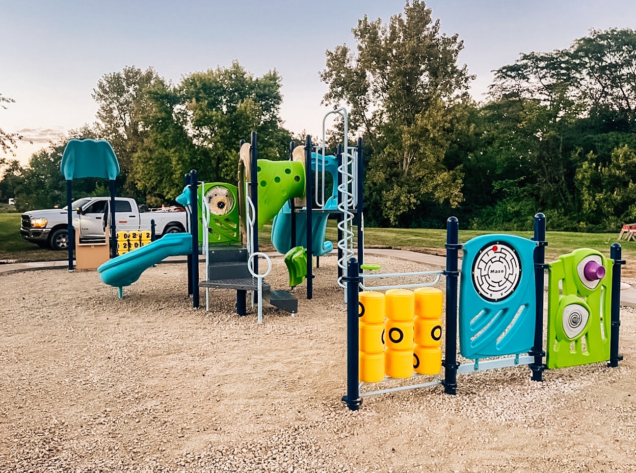 Activity panels mounted near a table and seat in a Lewistown playground.