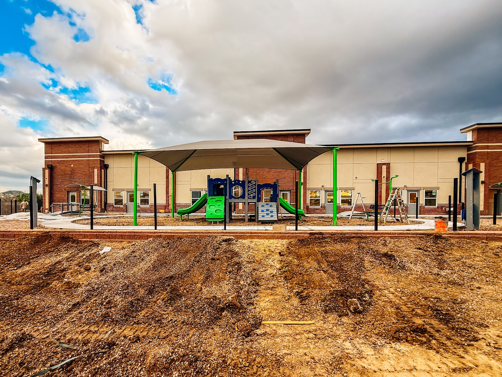Full view of the new playground at Kiddie Academy in Castle Rock, Colorado, featuring play structures, shade, and imaginative play elements.