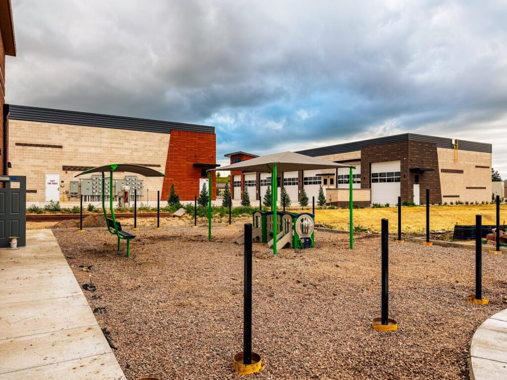 Large shade canopy installed over playground equipment at Kiddie Academy in Castle Rock, Colorado.