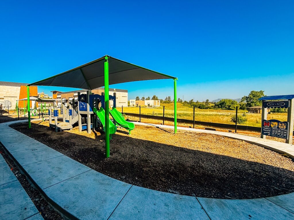 Colorful climbing structure with slides and activity panels at Kiddie Academy playground in Castle Rock, Colorado.
